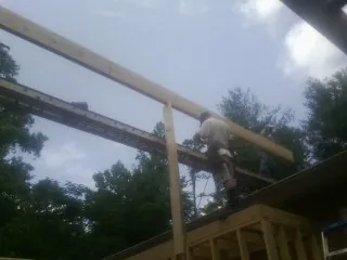 Carpenter setting a ridge beam over a new addition frame — Ice Dam Removal by Roofing Brothers in East Kingston