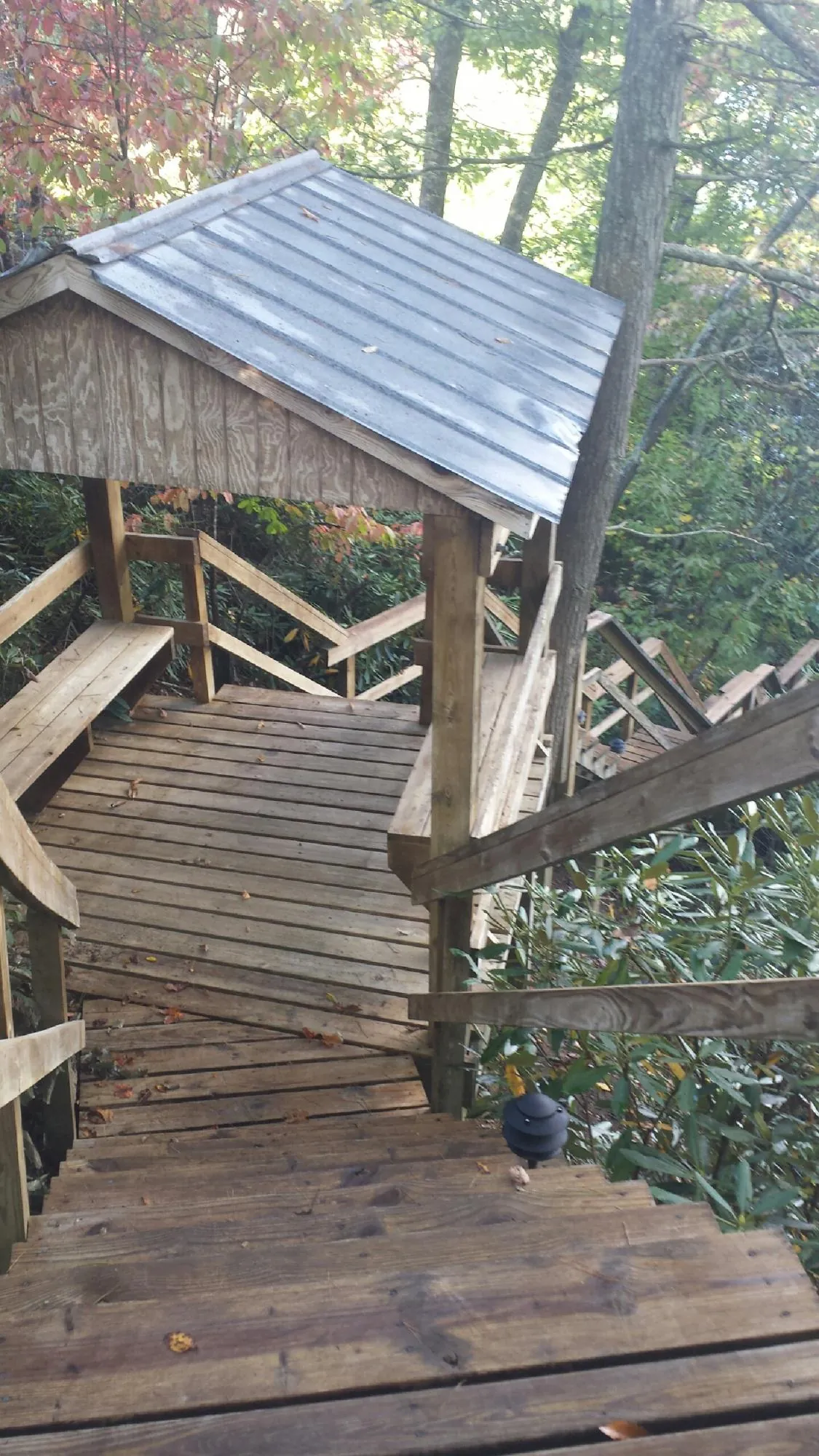 Metal roofed shelter over wooden steps on a wooded walkway — Skylight Repair & Installation work by our crew in East Kingston
