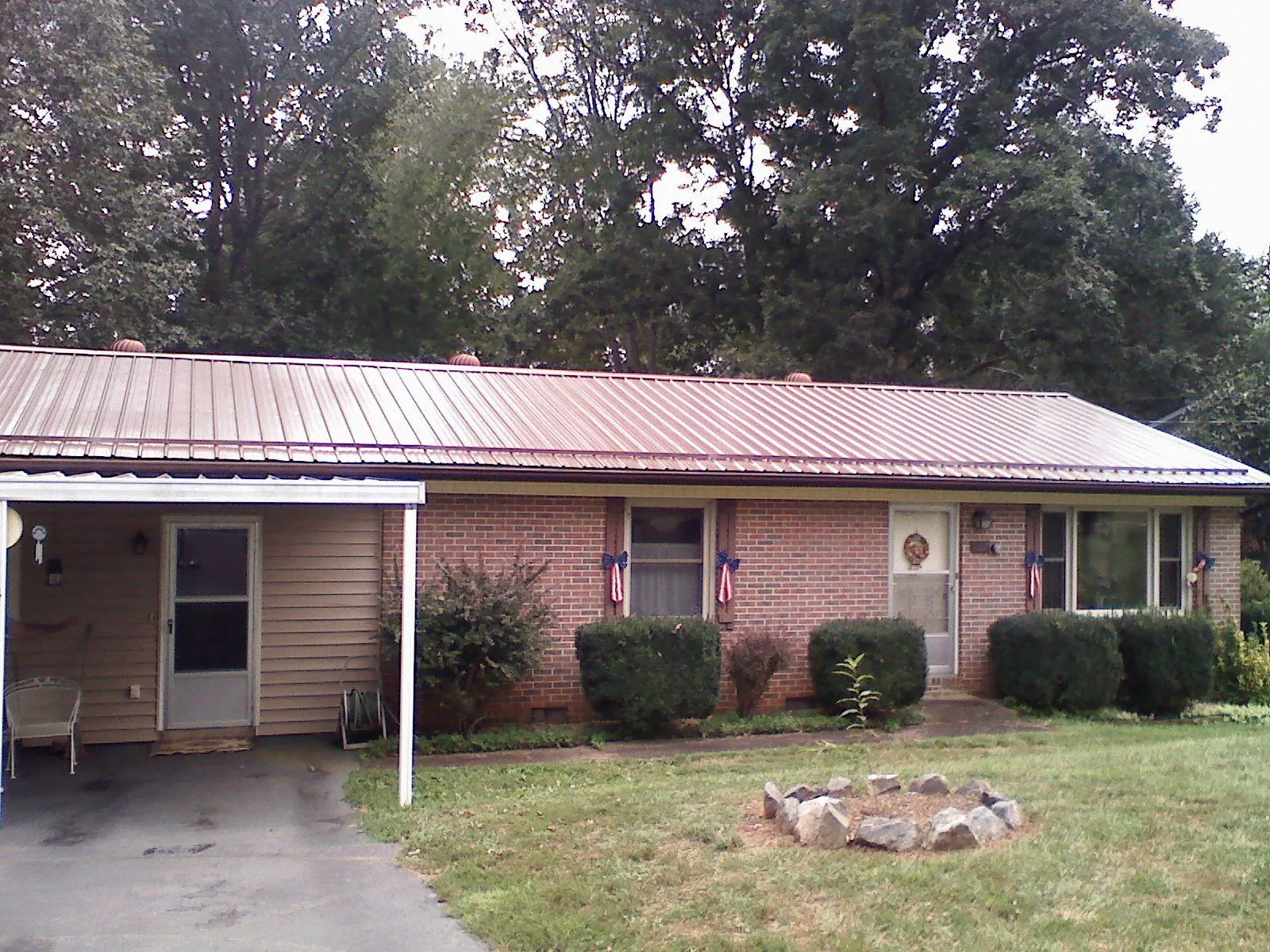 Bronze metal roof and carport on a brick ranch home — Roof Repair work by our crew in East Kingston